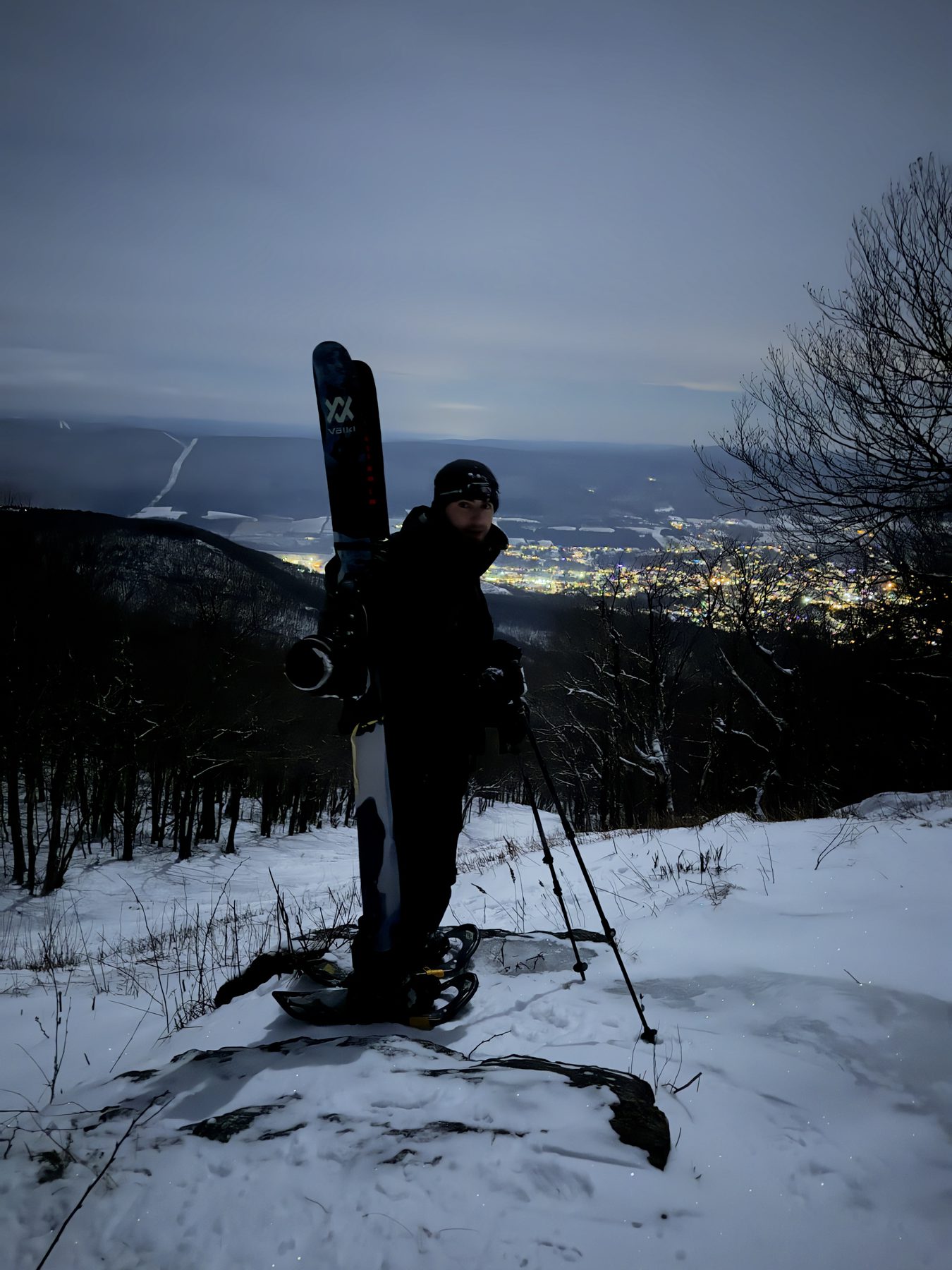 Backcountry ski touring at dusk on Mount Greylock, with valley lights below